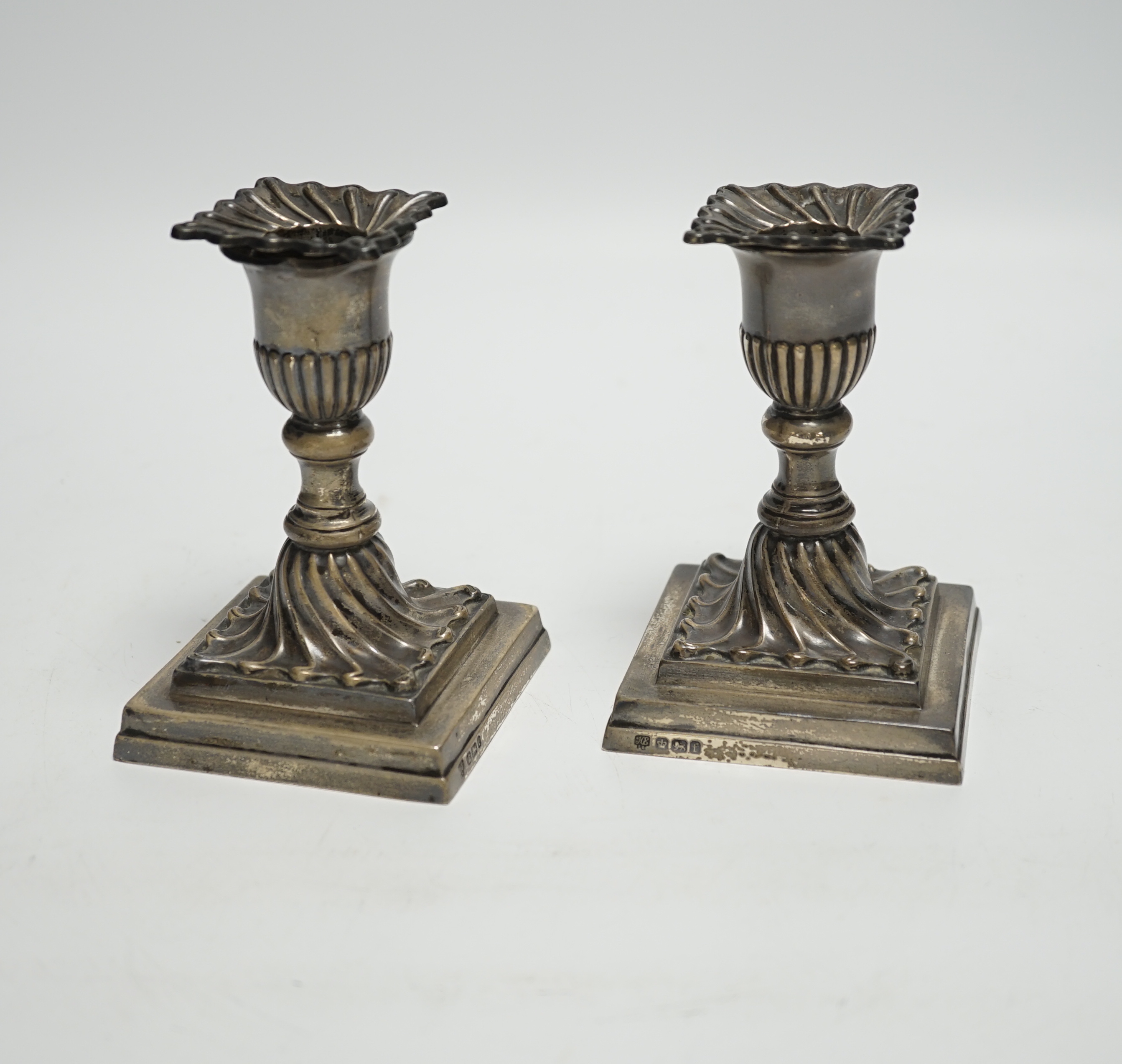 A pair of late Victorian wrythened silver mounted dwarf candlesticks, Hawksworth, Eyre & Co Ltd, Sheffield, 1897, 11.1cm, weighted.